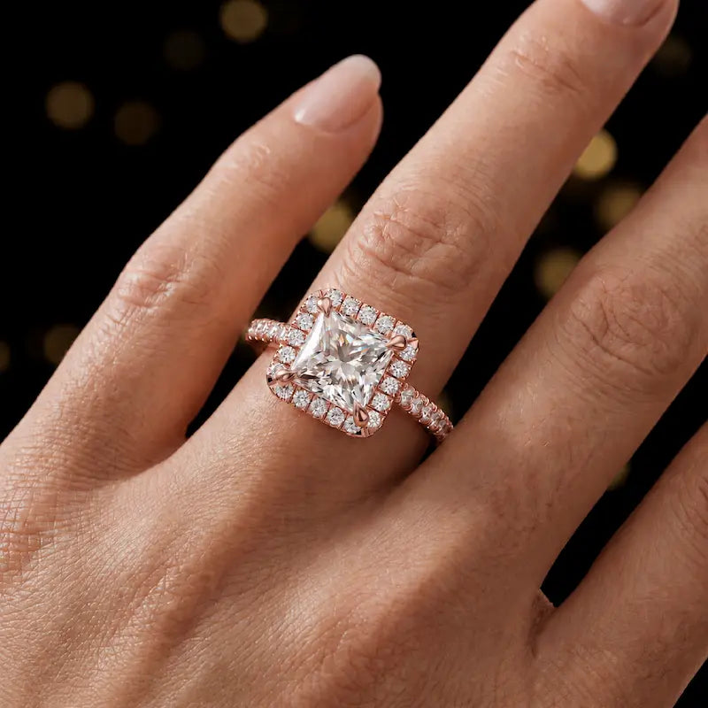 Princess cut halo lab-grown diamond engagement ring worn on hand in 18kt rose gold.