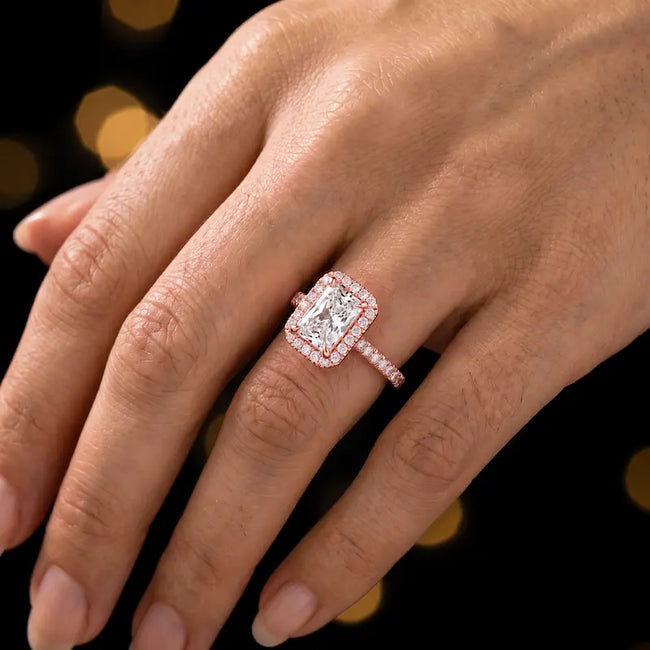 Radiant cut halo lab-grown diamond engagement ring worn on hand in 18kt rose gold.