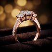 Angled view of a radiant cut three-stone lab-grown diamond engagement ring in 18kt rose gold with diamond shoulders