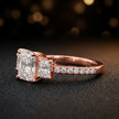 Side view of a radiant cut three-stone lab-grown diamond engagement ring in 18kt rose gold with diamond shoulders