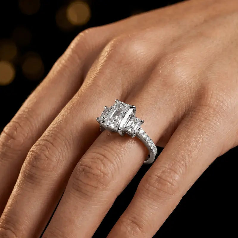 Radiant cut three-stone lab-grown diamond engagement ring in 18kt white gold with diamond shoulders worn on hand