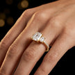 Radiant cut three-stone lab-grown diamond engagement ring in 18kt yellow gold with diamond shoulders worn on hand