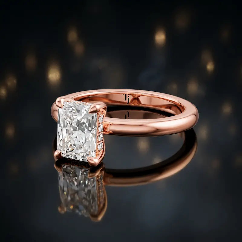Angled view of 4-claw radiant cut engagement ring with hidden halo in 18kt rose gold