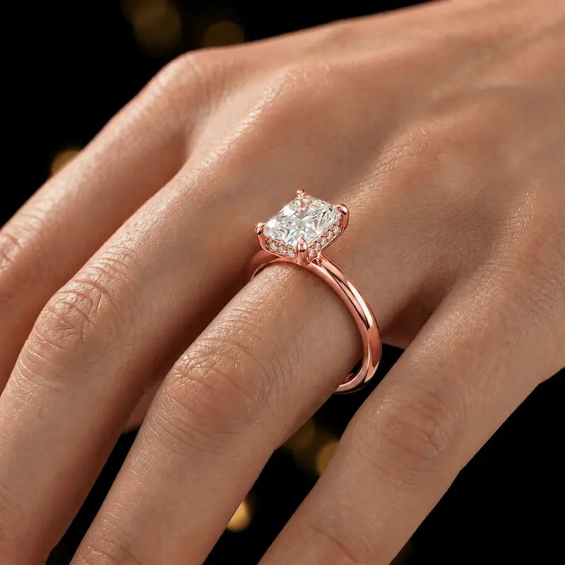 4-claw radiant cut engagement ring with hidden halo in 18kt rose gold, worn on hand