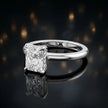 Angled view of 4-claw radiant cut engagement ring with hidden halo in 18kt white gold