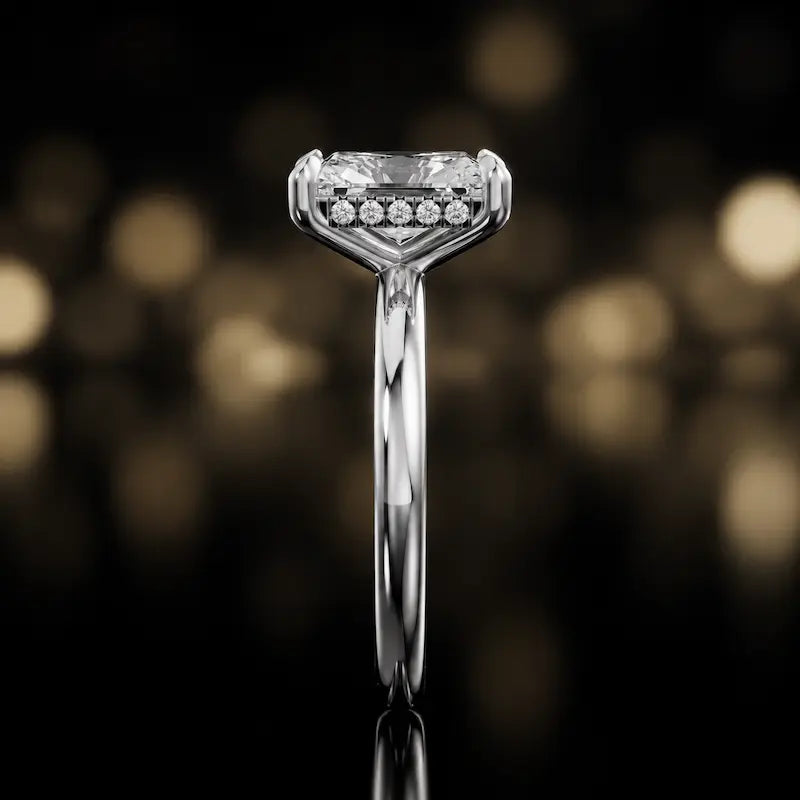 Side profile of 4-claw radiant cut engagement ring with hidden halo in 18kt white gold