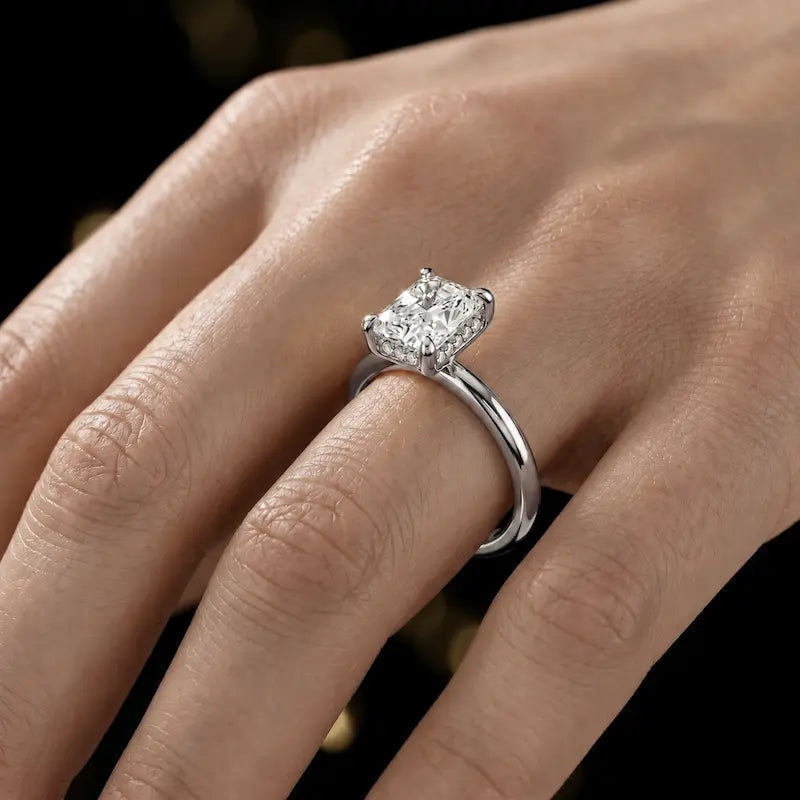4-claw radiant cut engagement ring with hidden halo in 18kt white gold, worn on hand