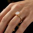 4-claw radiant cut engagement ring with hidden halo in 18kt yellow gold, worn on hand