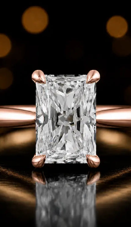 Front view of a 1.5 carat radiant cut diamond solitaire engagement ring in an 18kt rose gold 4 claw setting by TJ Diamond