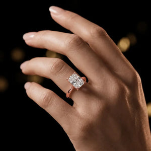 1.5 carat radiant cut diamond solitaire engagement ring in an 18kt rose gold 4 claw setting worn on a hand, by TJ Diamond