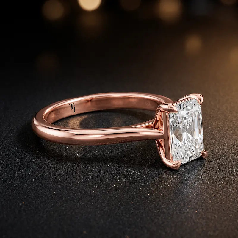 Angled side view of a 1.5 carat radiant cut diamond solitaire engagement ring in an 18kt rose gold 4 claw setting by TJ Diamond