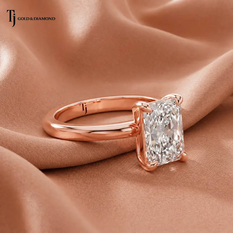 Angled side view of a 1.5 carat radiant cut diamond solitaire engagement ring in an 18kt rose gold 4 claw setting by TJ Diamond