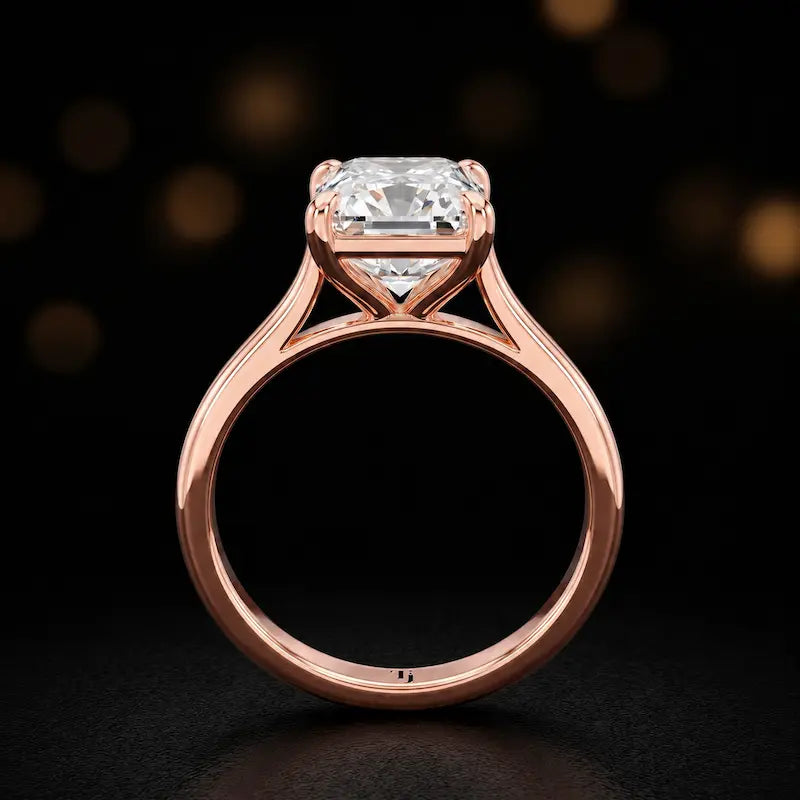 Front-on view of a 1.5 carat radiant cut diamond solitaire engagement ring showing the full 18kt rose gold band and 4 claw cathedral setting by TJ Diamond