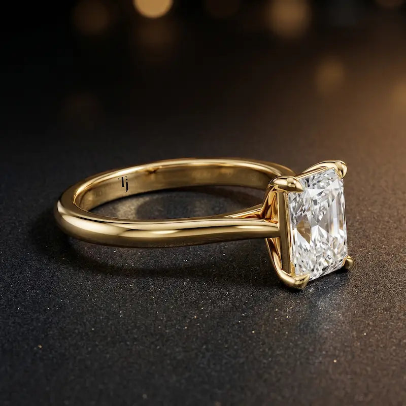 Angled side view of a 1.5 carat radiant cut diamond solitaire engagement ring in an 18kt yellow gold 4 claw setting by TJ Diamond