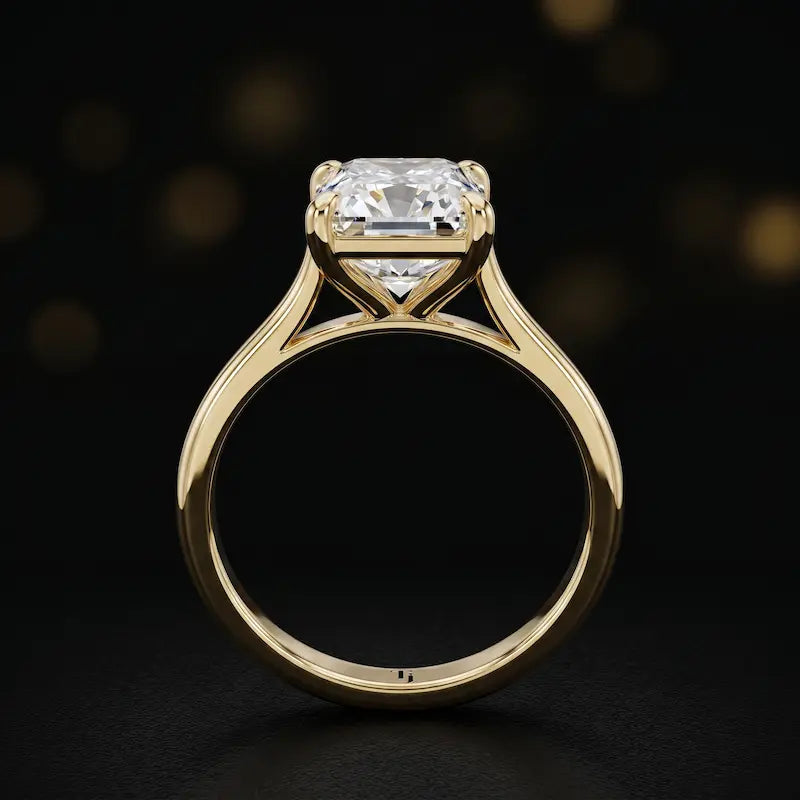 Front-on view of a 1.5 carat Radiant cut diamond solitaire engagement ring showing the full 18kt yellow gold band and 4 claw cathedral setting by TJ Diamond