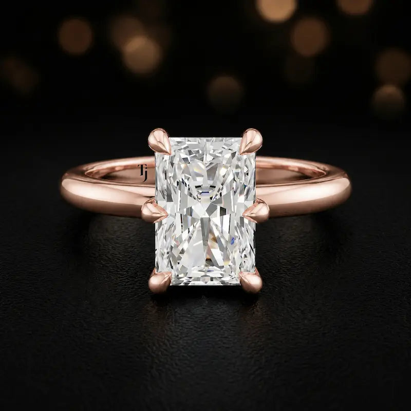 Front view of a 1.5 carat radiant cut diamond solitaire engagement ring in an 18kt rose gold 6 claw setting by TJ Diamond