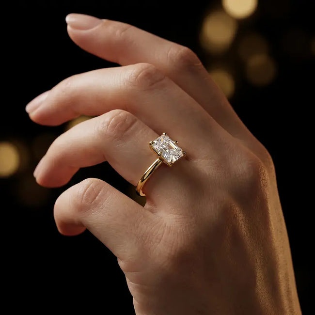 1.5 carat radiant cut diamond solitaire engagement ring in an 18kt yellow gold 6 claw setting worn on a hand, by TJ Diamond