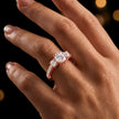 Round cut three-stone lab-grown diamond engagement ring in 18kt rose gold with diamond shoulders worn on hand