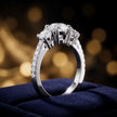 Angled view of a round cut three-stone lab-grown diamond engagement ring in 18kt white gold with diamond shoulders