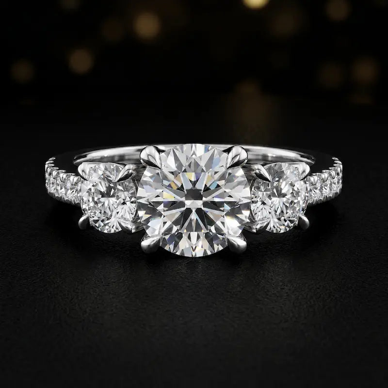 Front view of a round cut three-stone lab-grown diamond engagement ring in 18kt white gold with diamond shoulders