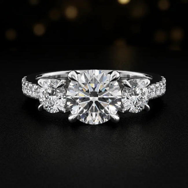 Front view of a round cut three-stone lab-grown diamond engagement ring in 18kt white gold with diamond shoulders