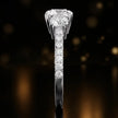 Side profile of a round cut three-stone lab-grown diamond engagement ring in 18kt white gold showing the diamond band