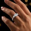 Round cut three-stone lab-grown diamond engagement ring in 18kt white gold with diamond shoulders worn on hand