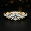 Front view of a round cut three-stone lab-grown diamond engagement ring in 18kt yellow gold with diamond shoulders