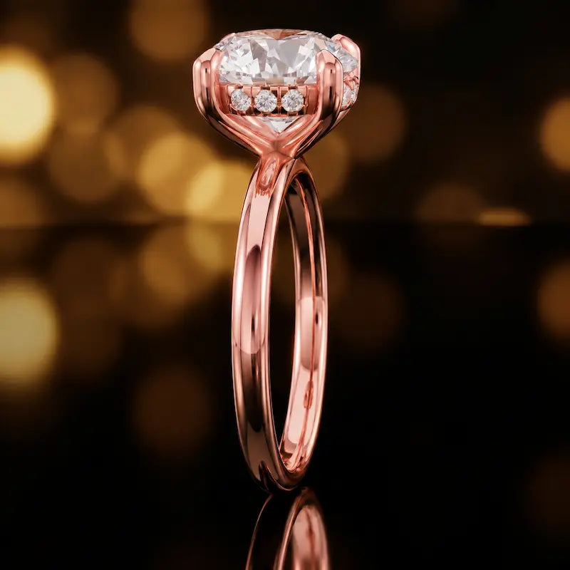 Side profile of 4-claw round cut engagement ring with hidden halo in 18kt rose gold