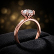 Side view of 4-claw round cut engagement ring with hidden halo in 18kt rose gold