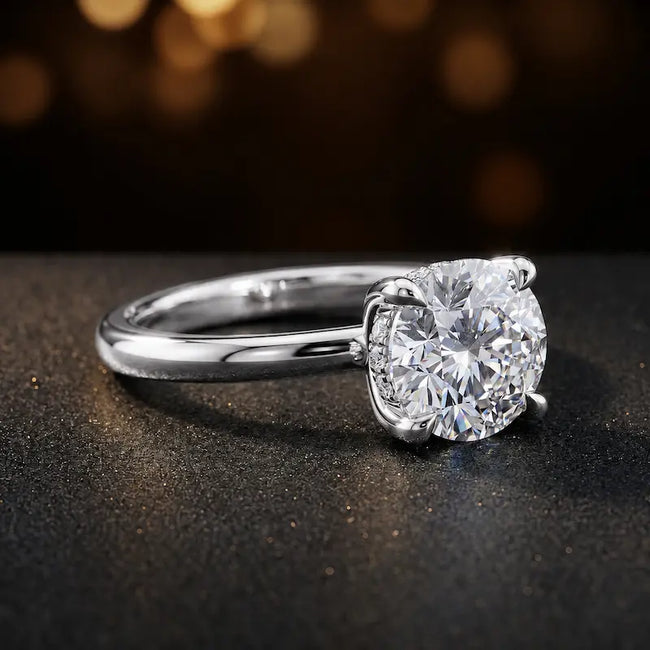 Angled view of 4-claw round cut engagement ring with hidden halo in 18kt white gold