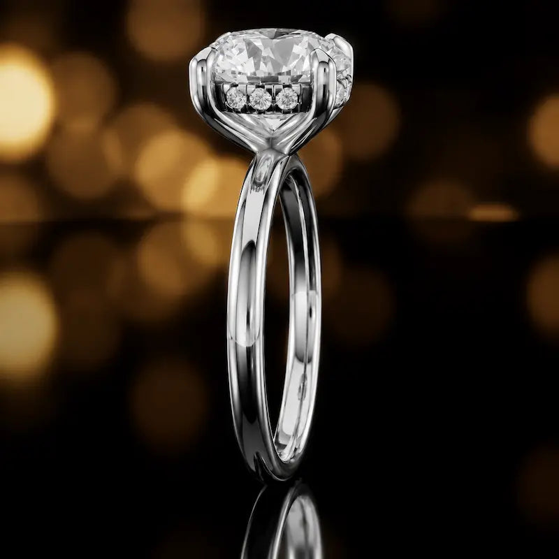 Side profile of 4-claw round cut engagement ring with hidden halo in 18kt white gold