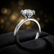 Side view of 4-claw round cut engagement ring with hidden halo in 18kt white gold