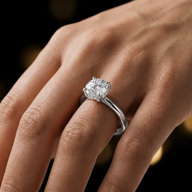 4-claw round cut engagement ring with hidden halo in 18kt white gold, worn on hand