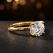 Angled view of 4-claw round cut engagement ring with hidden halo in 18kt yellow gold