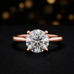 Front view of a 1.5 carat round brilliant cut diamond solitaire engagement ring in an 18kt rose gold 4 claw setting by TJ Diamond