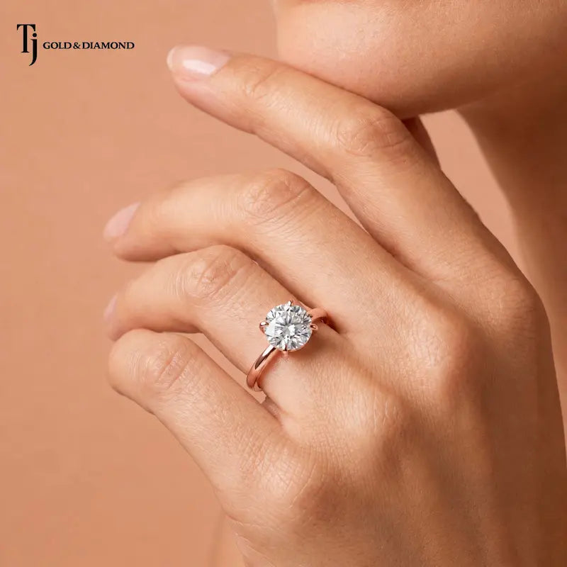 Close-up of a 1.5 carat round cut lab-grown diamond solitaire engagement ring in 18kt rose gold worn on hand