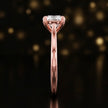 Side profile of a 1.5 carat round brilliant cut diamond solitaire engagement ring showing the cathedral setting and 18kt rose gold band by TJ Diamond