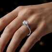 Round brilliant cut diamond solitaire engagement ring in an 18kt white gold 4 claw setting worn on a hand, by TJ Diamond