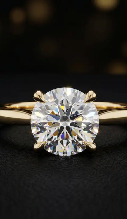 Front view of a 1.5 carat round brilliant cut diamond solitaire engagement ring in an 18kt yellow gold 4 claw setting by TJ Diamond