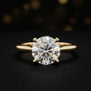 Front view of a 1.5 carat round brilliant cut diamond solitaire engagement ring in an 18kt yellow gold 4 claw setting by TJ Diamond