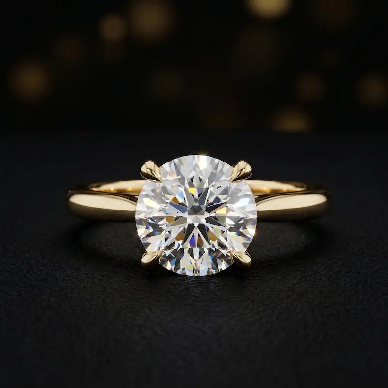 Front view of a 1.5 carat round brilliant cut diamond solitaire engagement ring in an 18kt yellow gold 4 claw setting by TJ Diamond