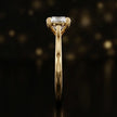 Front-on view of a 1.5 carat round brilliant cut diamond solitaire engagement ring showing the full 18kt yellow gold band and 4 claw cathedral setting by TJ Diamond