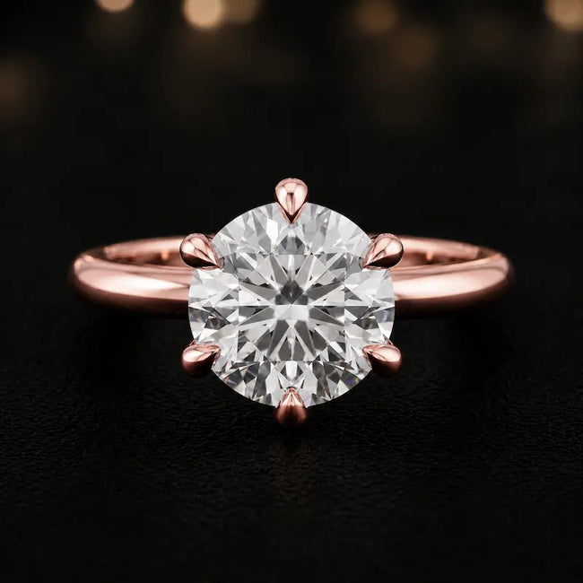 Front view of a 1.5 carat round brilliant cut diamond solitaire engagement ring in an 18kt rose gold 6 claw setting by TJ Diamond
