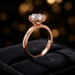 Front-on view of a 1.5 carat round brilliant cut diamond solitaire engagement ring presented in a TJ Diamond ring box, showing the full 18kt rose gold band and 6 claw cathedral setting