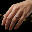 1.5 carat round brilliant cut diamond solitaire engagement ring in an 18kt yellow gold 6 claw setting worn on a hand, by TJ Diamond