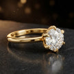 Angled side view of a 1.5 carat round brilliant cut diamond solitaire engagement ring in an 18kt yellow gold 6 claw setting by TJ Diamond
