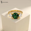 Front View of a round cut lab-created emerald trilogy engagement ring in 18kt yellow gold with round brilliant lab-grown diamond side stones.