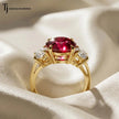 Rear view of a round brilliant lab-created ruby trilogy engagement ring in 18kt yellow gold showcasing the open four claw basket setting and round brilliant lab-grown diamond side stones.
