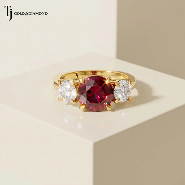 Front view of a round brilliant lab-created ruby trilogy engagement ring in 18kt yellow gold with round brilliant lab-grown diamond side stones.